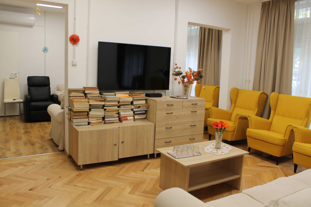 Idősek nappali ellátása - Kereszttöltés utca - társalgó fotelokkal, könyvekkel, TV-vel