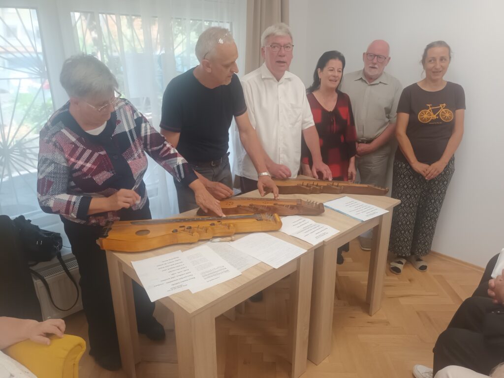 A citerazenekar előadása. Három citerán játszanak.